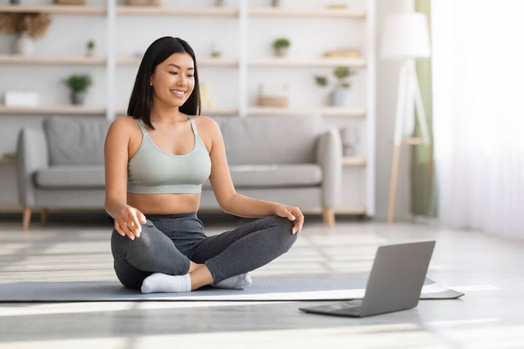 Explorer les Avantages du Coaching en Ligne Avec Possible Factory 1 online yoga young asian woman using laptop for pr 2022 12 16 08 58 48 utc