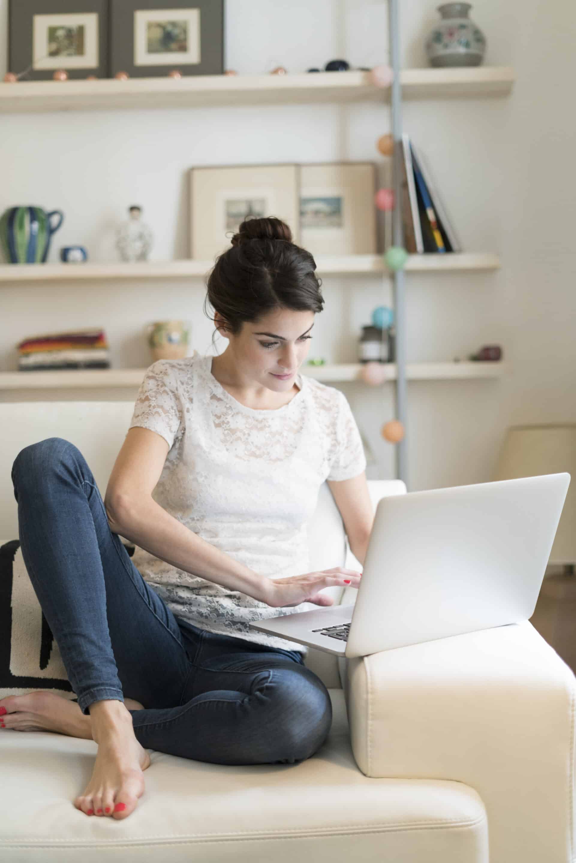 woman sitting on couch at home using laptop 2023 11 27 05 17 32 utc scaled